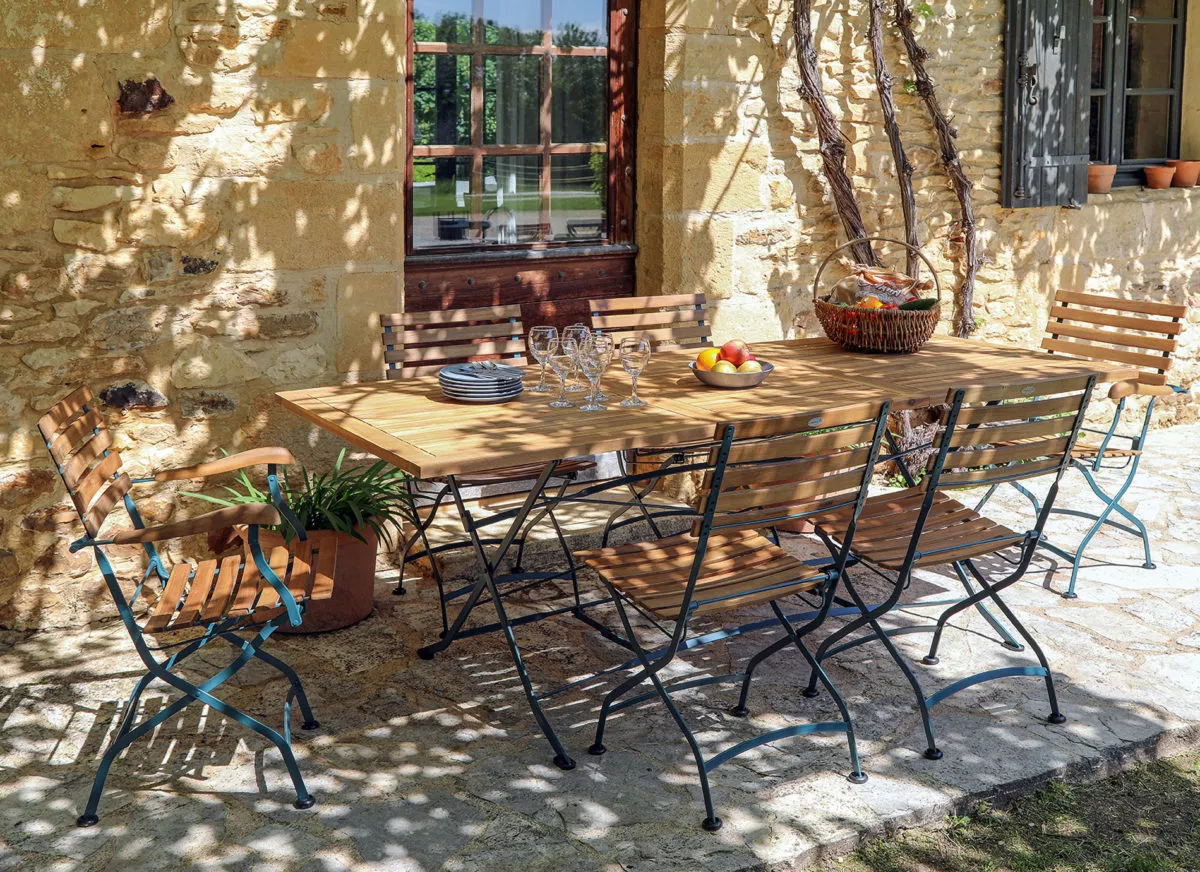 Une table et des chaises de jardin en teck et fer forgé, issue du site https://www.jarditeck-by-medicis.com/