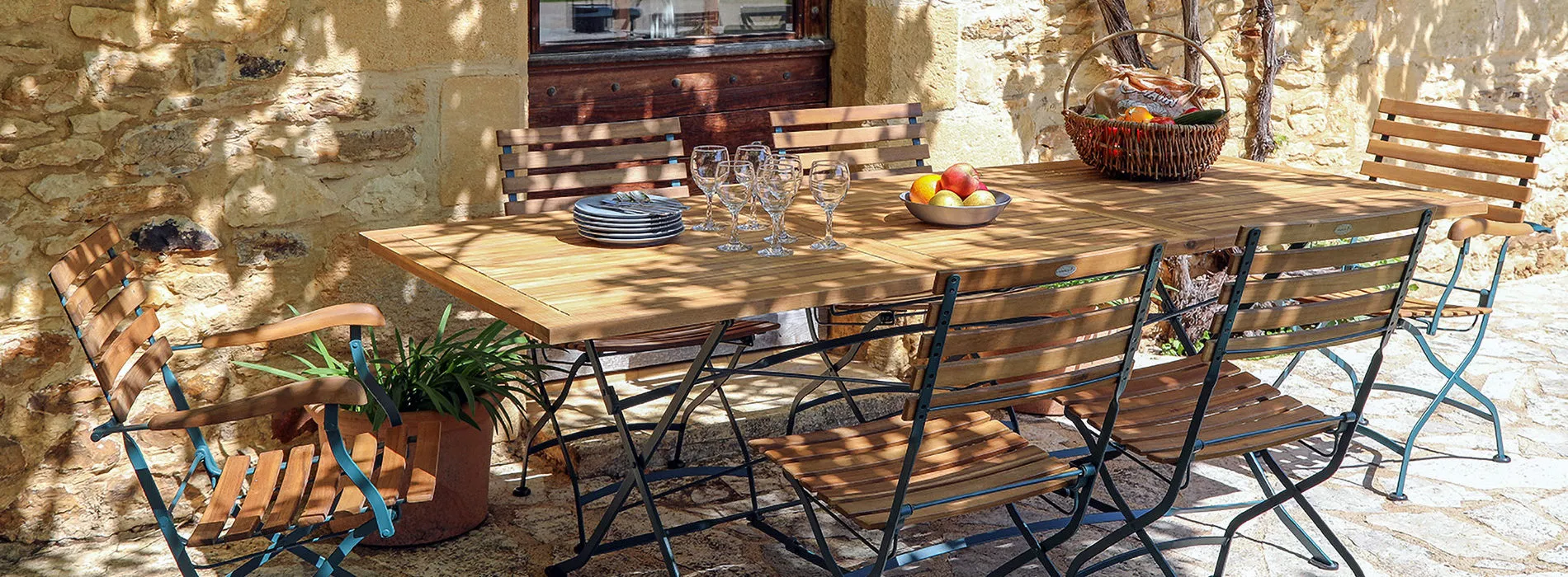 Une table et des chaises de jardin en teck et fer forgé, issue du site https://www.jarditeck-by-medicis.com/